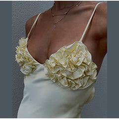 White floral top worn by a person against a gray background