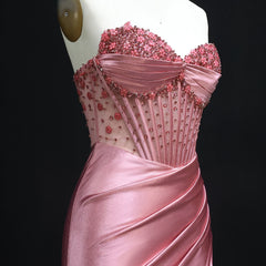 Pink evening gown with intricate beading on a mannequin against a black background