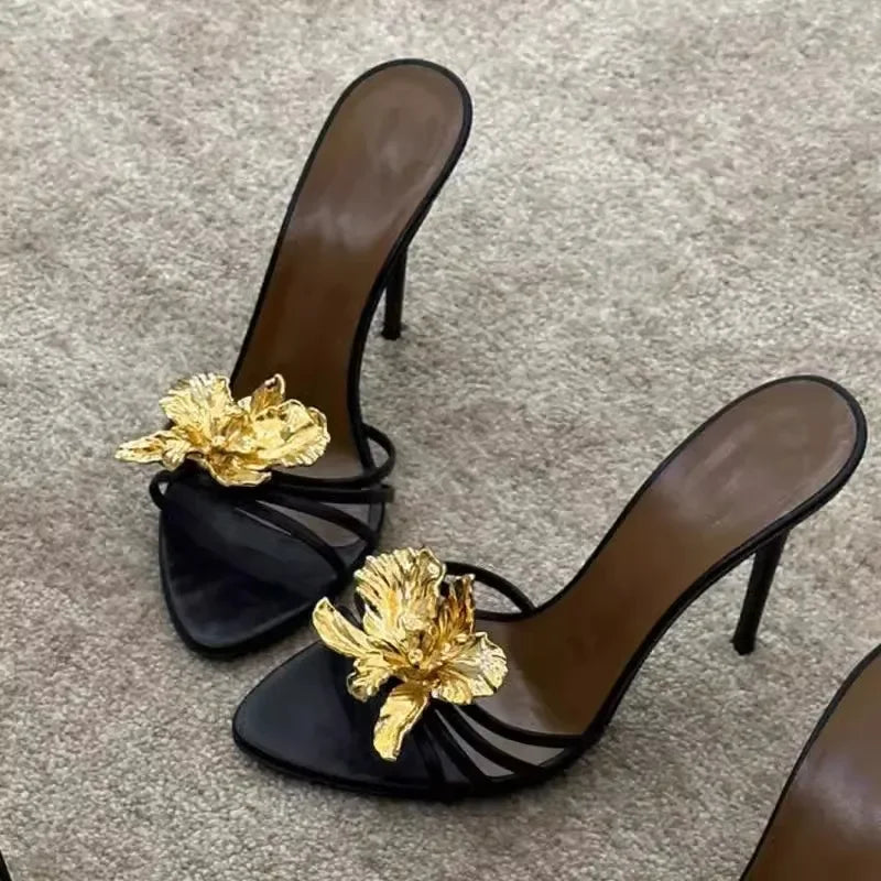 Close-up of black stiletto heels with gold floral detail