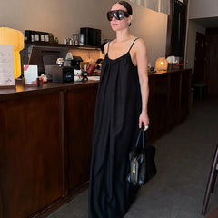 Woman wearing a solid black maxi dress with spaghetti straps in a cafe
