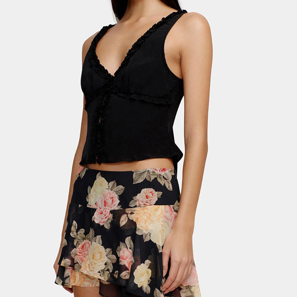 Black sleeveless top with floral skirt on a white background