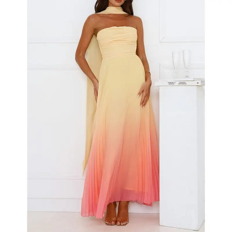 Woman wearing a strapless, floor-length dress with a gradient from yellow to pink against a white background.