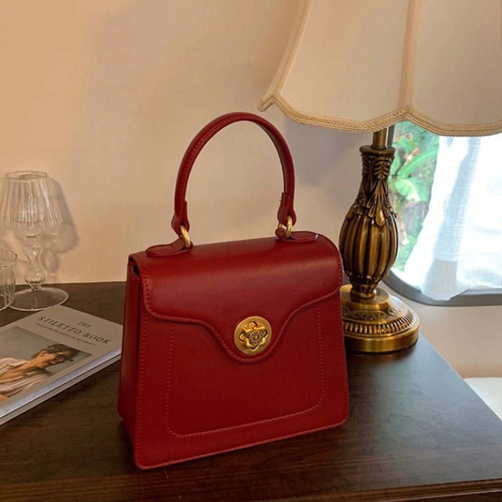 Red structured top handle bag on a table