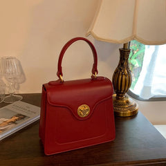 Red structured top handle bag on a table