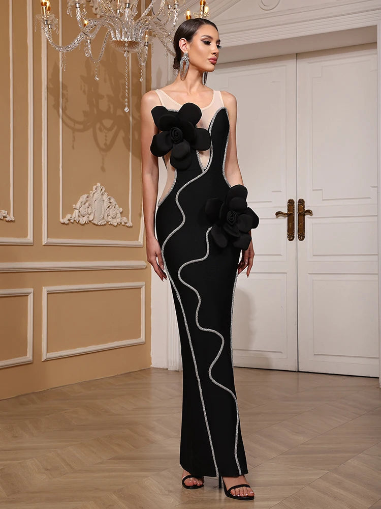 Woman in a black and white evening gown with floral details in an elegant room.