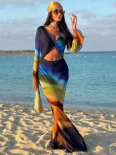 Woman in a colorful outfit standing on a beach with ocean in the background