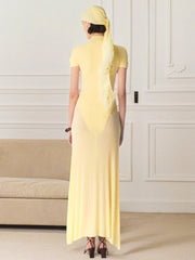Woman wearing a yellow dress and headscarf in an indoor setting