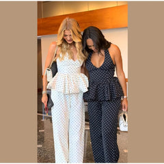 Two women wearing polka dot outfits walking together.