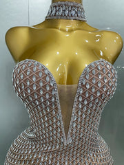 Mannequin wearing a sparkling, intricately designed top with a neutral background