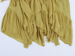 Close-up of yellow ruffled asymmetric hemline flowy skirt fabric detail