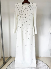 White long sleeve maxi dress with all-over rhinestone embellishments displayed on a hanger