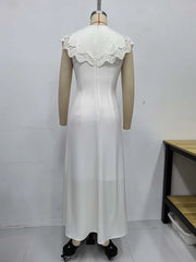 White dress with lace details on a mannequin against a plain background