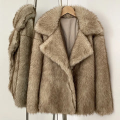 Beige faux fur coat on a hanger against a white background
