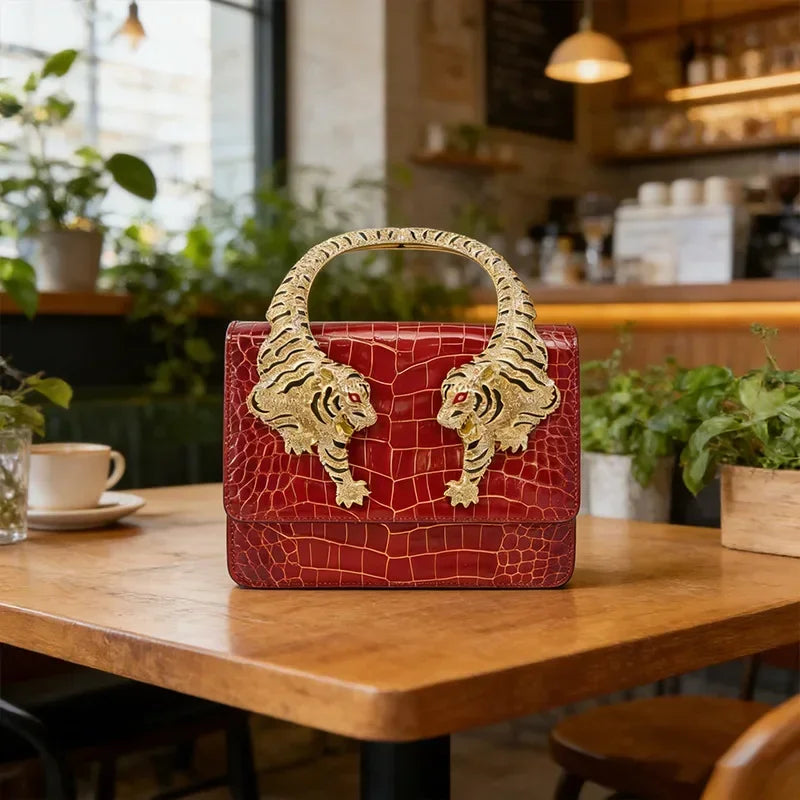 Red embossed leather handbag with sculpted tiger handle