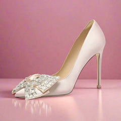High-heeled shoe with decorative bow on a light gray background