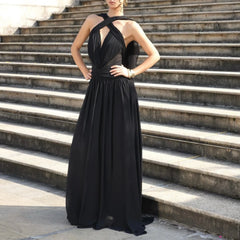 Woman in a black evening gown standing on stone steps.