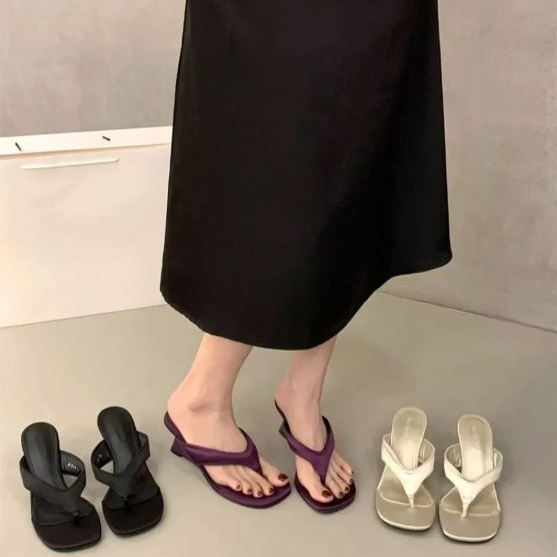 Assortment of wedge flip-flop sandals in black, purple, and white