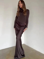 Model wearing brown draped cutout turtleneck maxi dress