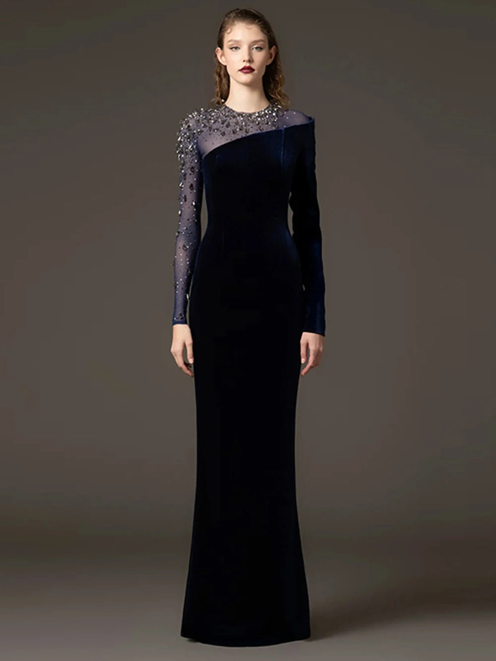 Velvet sheath gown with beaded mesh sleeves styled for evening wear