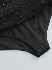 Close-up of a black garment with a textured pattern on a light gray background