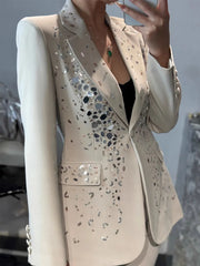 Beige blazer with decorative patterns on a blurred background