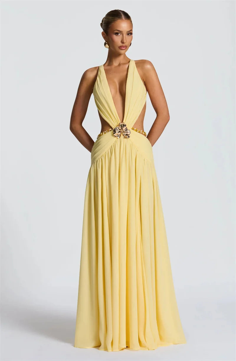 Yellow evening gown with a deep neckline and embellishments on a white background