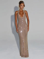 Woman wearing a sparkly gold evening gown against a plain background