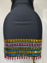 Mannequin wearing a colorful beaded top with a plain background