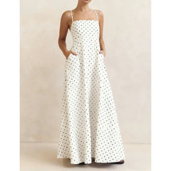 White dress with black polka dots on a neutral background
