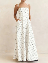 White dress with black polka dots on a neutral background