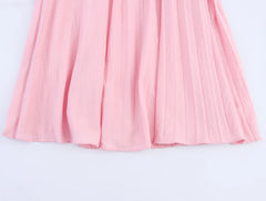 Pink pleated skirt on a light gray background