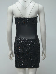 Black sequin dress on a mannequin against a gray background