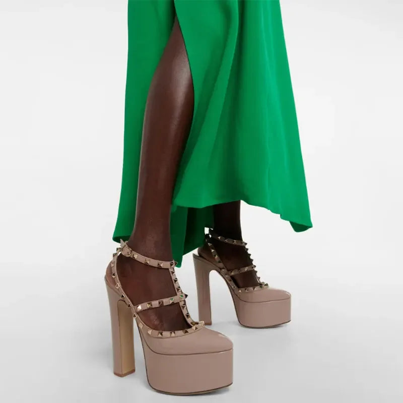Beige high-heeled platform shoes with studded details worn with a green dress.
