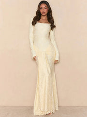 Woman wearing a long, light-colored dress against a beige background