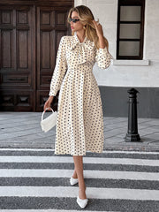 Woman in a polka dot dress crossing a zebra crossing.