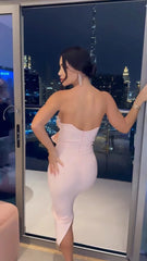 Woman in a strapless dress standing in front of a city skyline view.