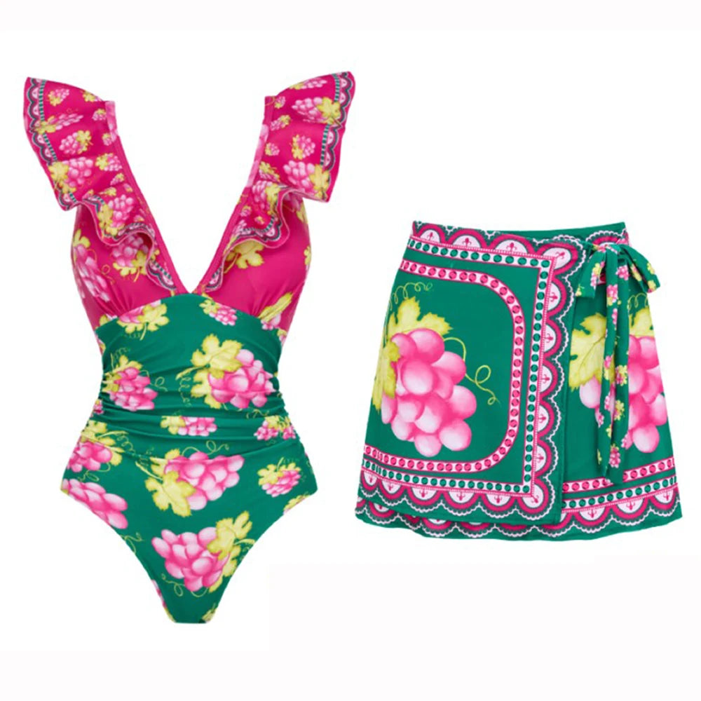 Green swimsuit with ruffled straps and grape print, paired with a wrap-style mini skirt