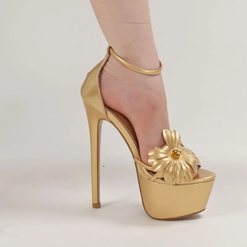 Gold high-heeled shoe with a platform and decorative element on a light background
