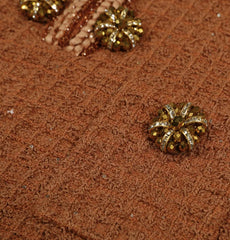 Close-up of a brown textured fabric with decorative gold buttons.