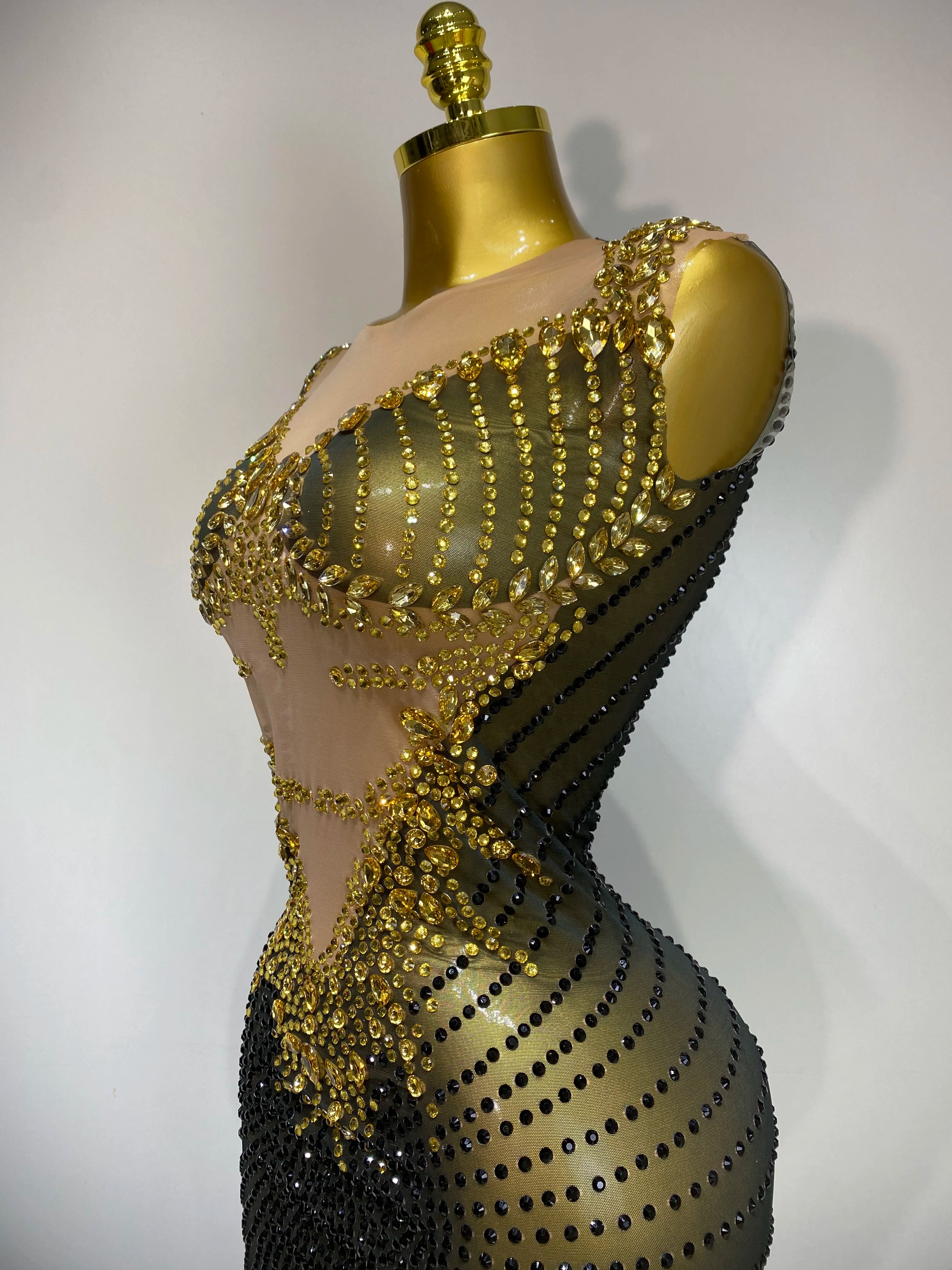 Mannequin wearing a black and gold beaded outfit on a white background