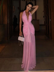 Woman in a pink dress holding a white clutch in an indoor setting