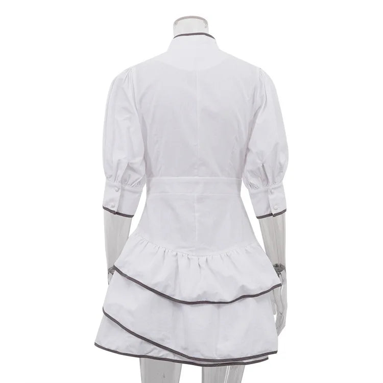 White dress with black trim on a mannequin against a white background