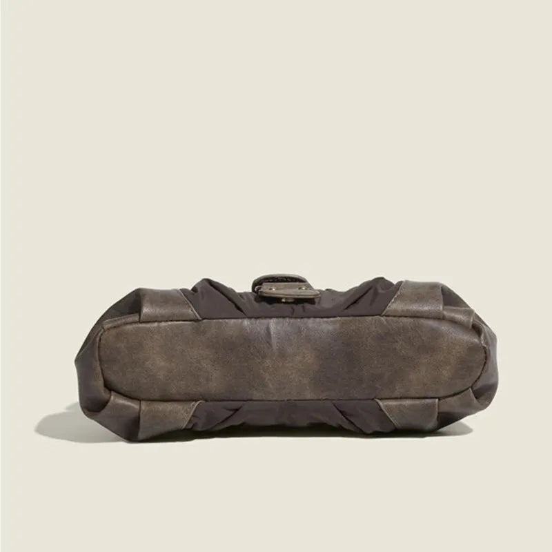 Brown leather duffel bag on a beige background