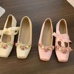 Pink ballet flats with floral embellishments and ribbon ties
