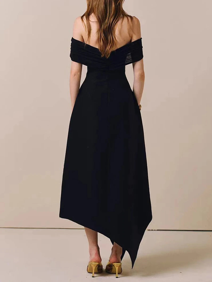 Black off-shoulder dress worn by a person on a beige background