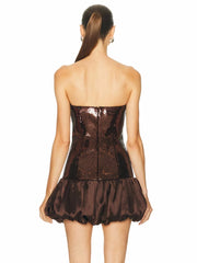 Brown strapless dress with ruffled skirt on a white background