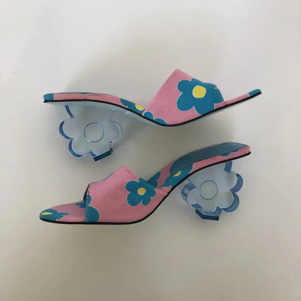 Top-down view of pink floral print mules with clear acrylic flower heels
