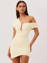 Woman wearing a light yellow one-shoulder dress on a plain background