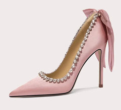 Pink high-heeled shoe with decorative elements on a white background