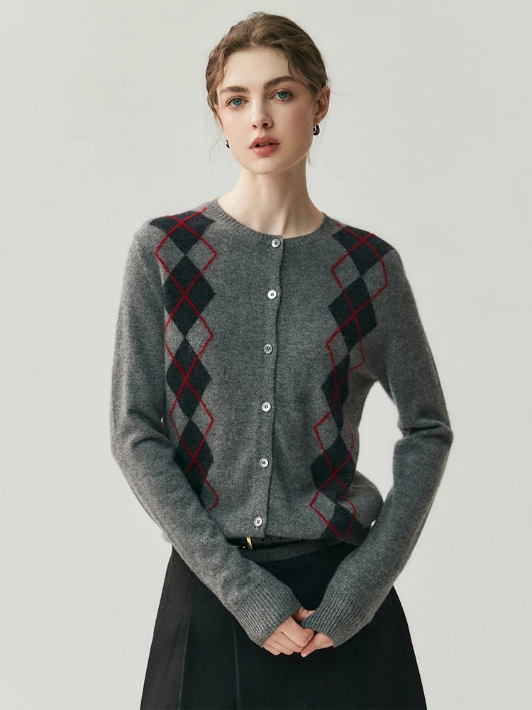 Woman wearing a gray cardigan with a geometric pattern on a plain background